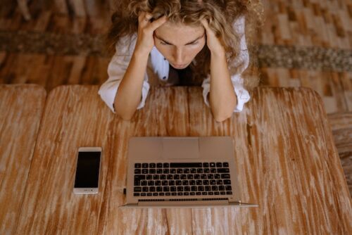 woman stressed on laptop looking at online threats
