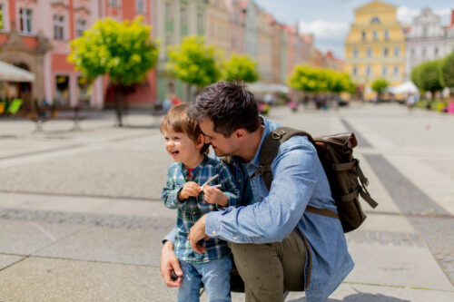 Father with a toddler boy in old city center.
