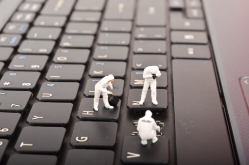 The figure of Crime Scene Investigation on keyboard. Cyber crimes concept. Selective focus.