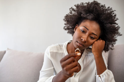 Unhappy woman holding wedding ring close up, upset girl crying, depressed with divorce, break up with boyfriend, broken engagement, feeling desperate, family split, bad relationships